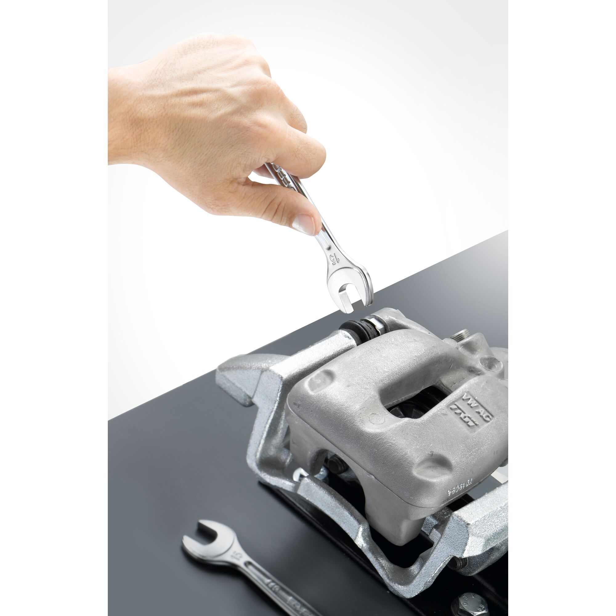Facom 440_20 open-end wrench used to adjust a metal brake caliper, photo shows top angle view.